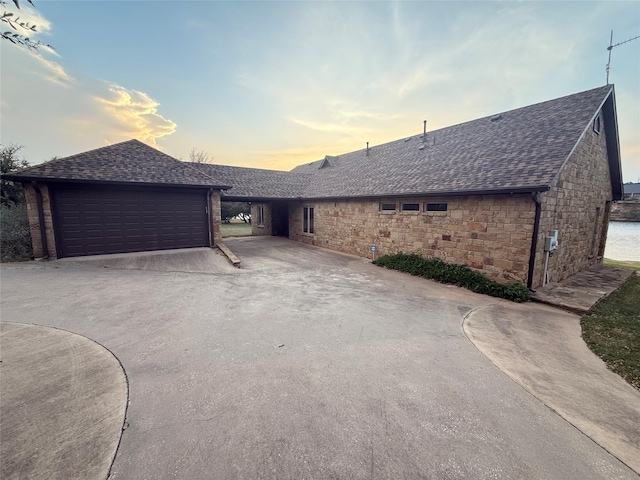 single story home with stone siding and a shingled roof