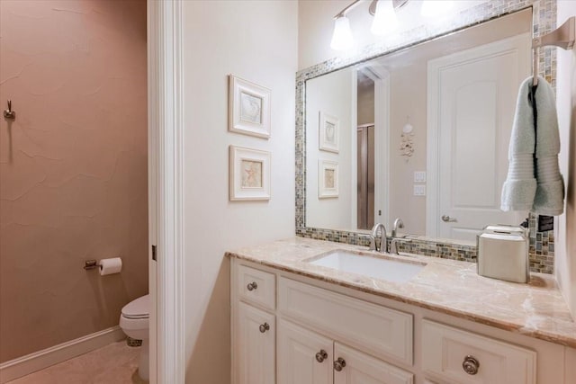 full bath with baseboards, vanity, tile patterned flooring, and toilet