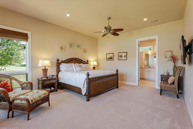 bedroom featuring light carpet, baseboards, ensuite bath, visible vents, and recessed lighting