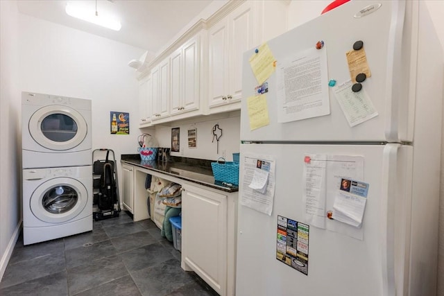clothes washing area featuring stacked washer / dryer and laundry area