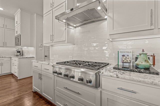kitchen with stainless steel appliances, white cabinetry, backsplash, under cabinet range hood, and recessed lighting
