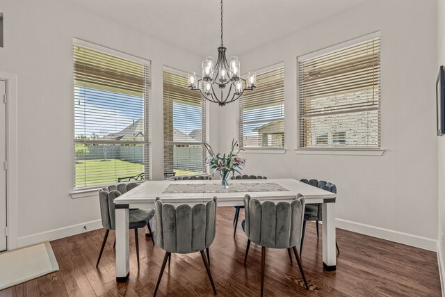 dining area with dark wood-type flooring, baseboards, a chandelier, and a healthy amount of sunlight