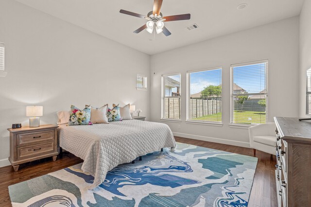 bedroom featuring visible vents, baseboards, dark wood-style floors, and ceiling fan