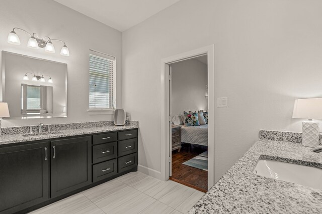 ensuite bathroom with two vanities, ensuite bathroom, a sink, and tile patterned flooring