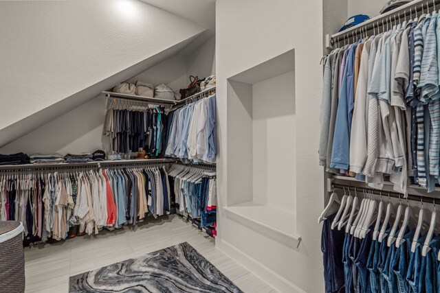 walk in closet featuring vaulted ceiling