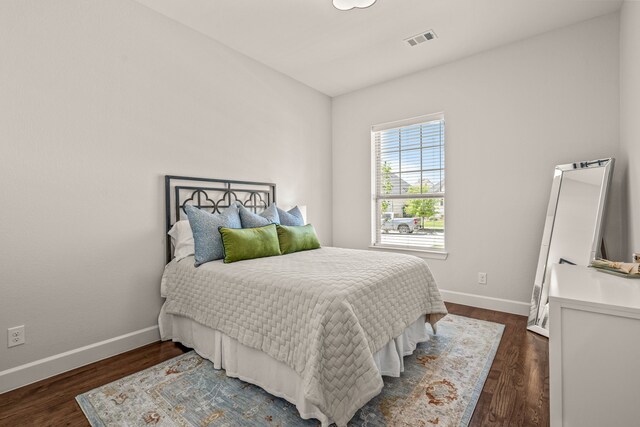 bedroom with visible vents, baseboards, and dark wood-style flooring