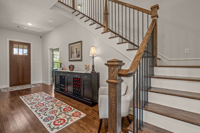 entrance foyer with dark wood-style floors, visible vents, baseboards, recessed lighting, and stairway