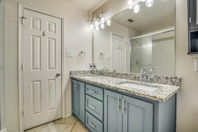 bathroom with tile patterned flooring, a sink, double vanity, and a stall shower