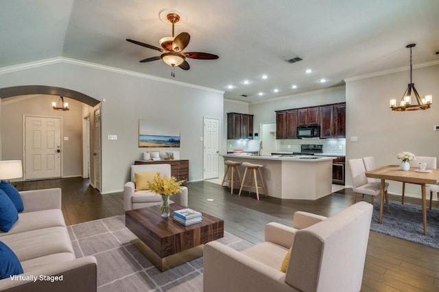 living room featuring arched walkways, visible vents, dark wood-style floors, and ceiling fan with notable chandelier