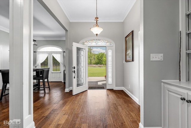 foyer with ornamental molding, baseboards, and dark wood-style flooring