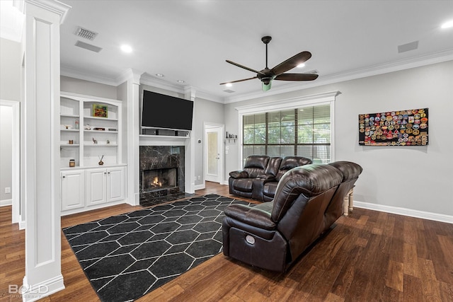 living room with visible vents, a high end fireplace, wood finished floors, and ceiling fan