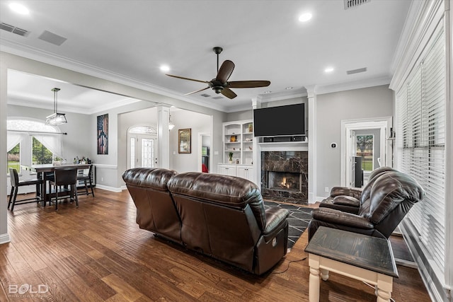 living area with dark wood-style floors, baseboards, visible vents, and a premium fireplace