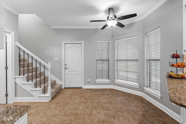 foyer featuring tile patterned floors, baseboards, a ceiling fan, stairs, and crown molding