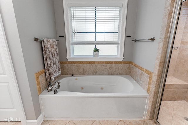bathroom featuring tile patterned flooring, a whirlpool tub, and a stall shower