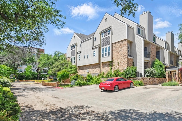 view of building exterior featuring a residential view and uncovered parking