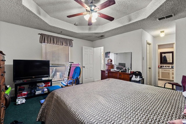 1502 Hinchliffe Rd, Mexia, TX 76667 - carpeted bedroom with ceiling fan, a tray ceiling, a textured ceiling, and visible vents