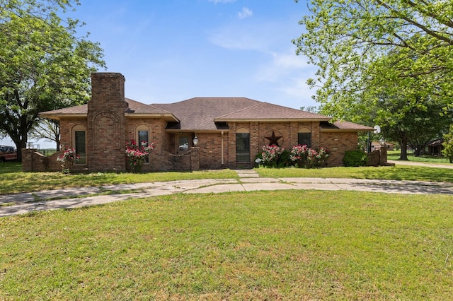 1502 Hinchliffe Rd, Mexia, TX 76667 - ranch-style house with brick siding, roof with shingles, a chimney, and a front yard