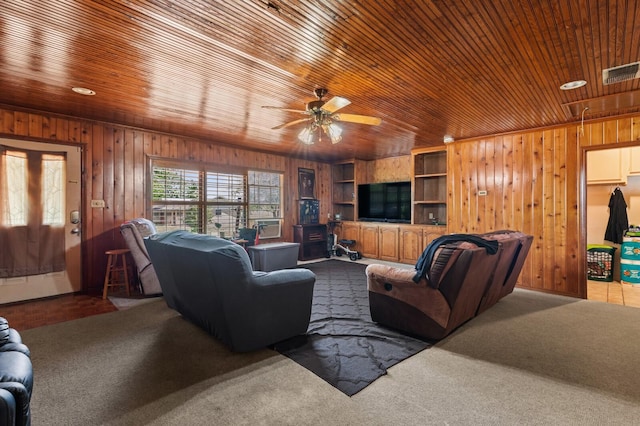 1502 Hinchliffe Rd, Mexia, TX 76667 - carpeted living room featuring wooden walls, visible vents, wooden ceiling, attic access, and ceiling fan