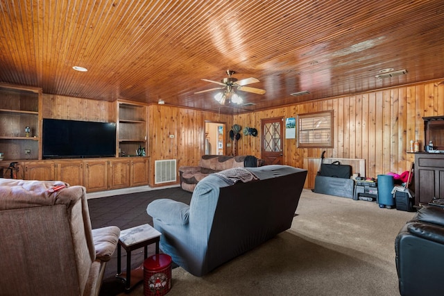 1502 Hinchliffe Rd, Mexia, TX 76667 - living room with wooden walls, dark carpet, visible vents, a ceiling fan, and wooden ceiling