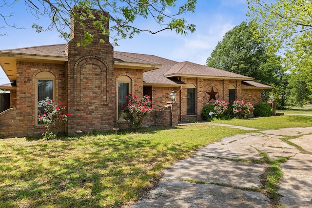 1502 Hinchliffe Rd, Mexia, TX 76667 - view of front of property featuring a shingled roof, a front lawn, brick siding, and a chimney