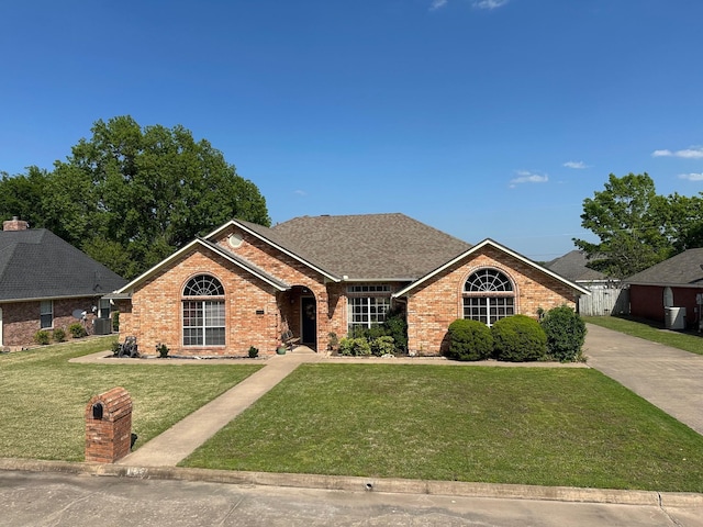 ranch-style house featuring brick siding and a front yard