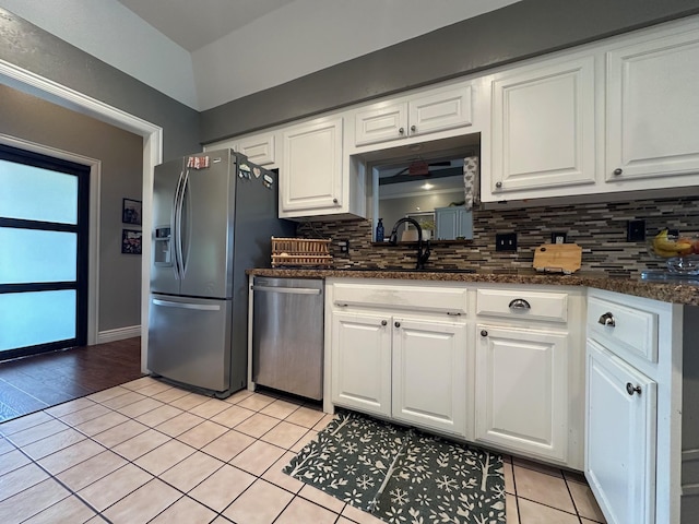 kitchen featuring white cabinets, stainless steel appliances, backsplash, and light tile patterned flooring