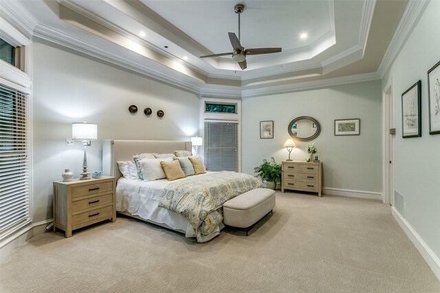 bedroom with visible vents, ornamental molding, light carpet, ceiling fan, and a tray ceiling
