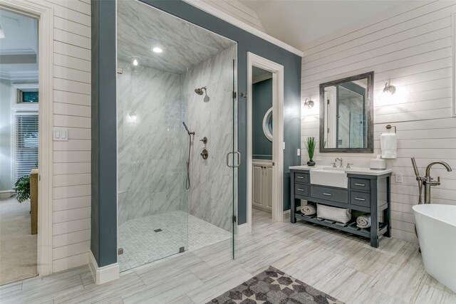 bathroom with baseboards, a freestanding tub, a marble finish shower, and vanity