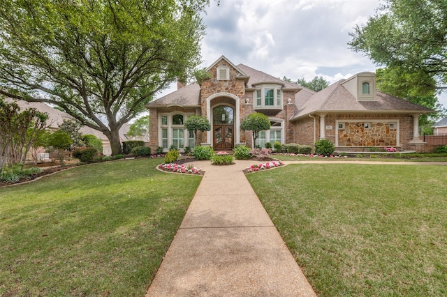 view of front of home with brick siding, stone siding, and a front yard
