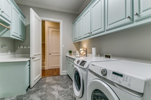 washroom featuring crown molding, cabinet space, a sink, baseboards, and washer and dryer