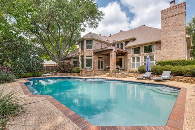 view of pool with fence, a pool with connected hot tub, and a patio area