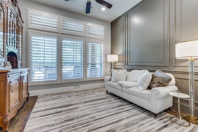 interior space with recessed lighting, wood finished floors, a decorative wall, and ceiling fan