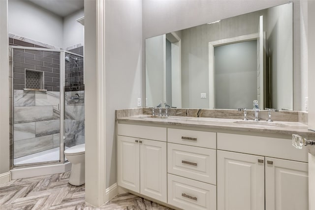 full bath with double vanity, toilet, a stall shower, and a sink