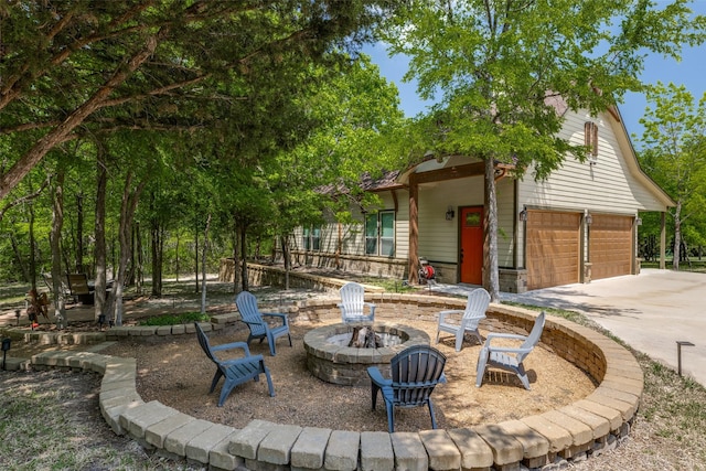 view of patio / terrace with concrete driveway and an outdoor fire pit