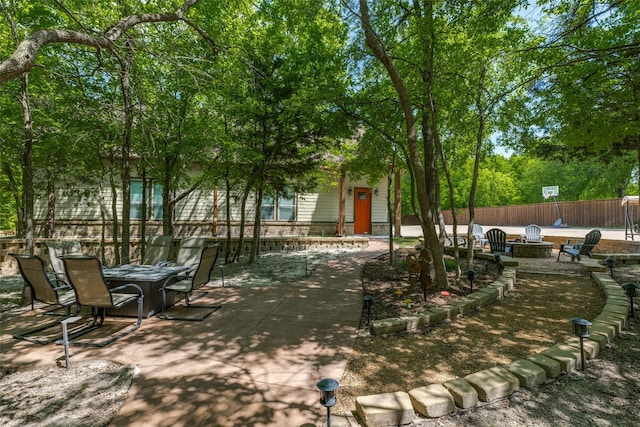 view of yard featuring a patio, an outdoor fire pit, and fence