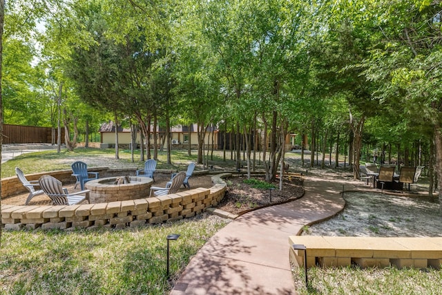 view of home's community with fence, a patio, and an outdoor fire pit