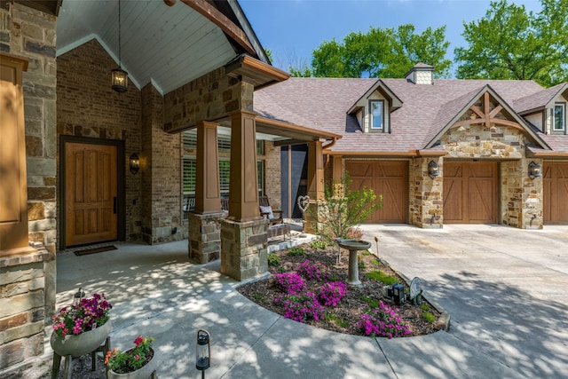 view of front of house featuring a chimney, a shingled roof, concrete driveway, stone siding, and brick siding