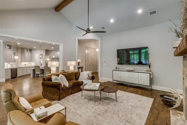 living area with beamed ceiling, wood finished floors, visible vents, and baseboards