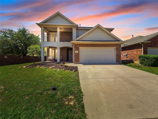 view of front facade with a front lawn, a balcony, driveway, covered porch, and a garage