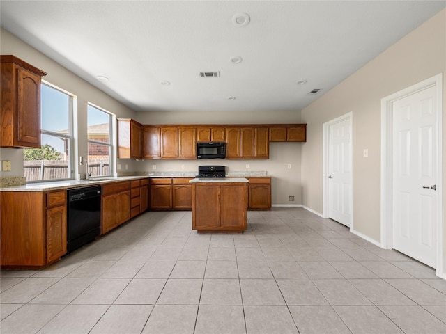 kitchen featuring light countertops, visible vents, brown cabinets, and black appliances