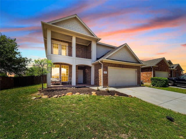 view of front of house with a lawn, driveway, an attached garage, a porch, and brick siding