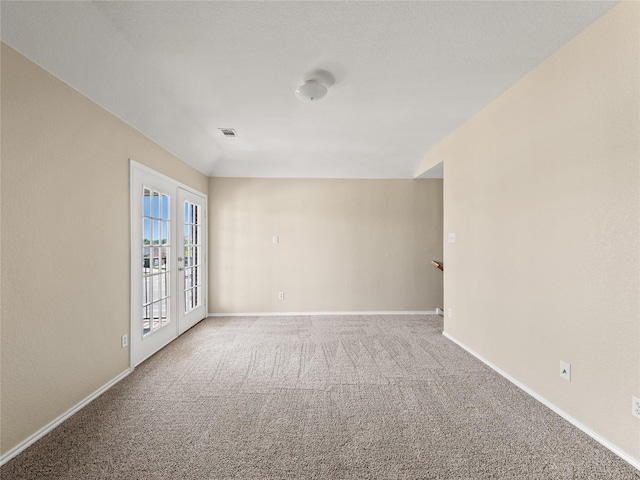 spare room with carpet, visible vents, and baseboards