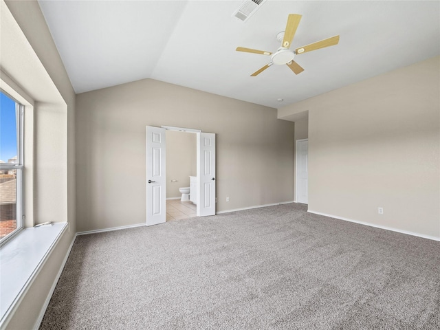 unfurnished room featuring vaulted ceiling, ceiling fan, carpet, baseboards, and visible vents