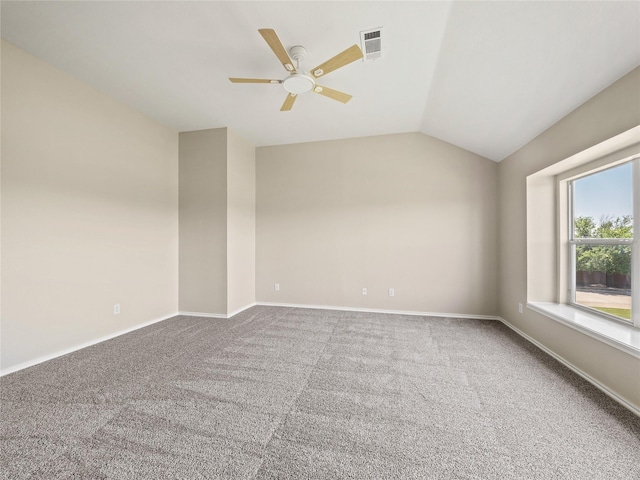carpeted empty room with lofted ceiling, baseboards, a ceiling fan, and visible vents