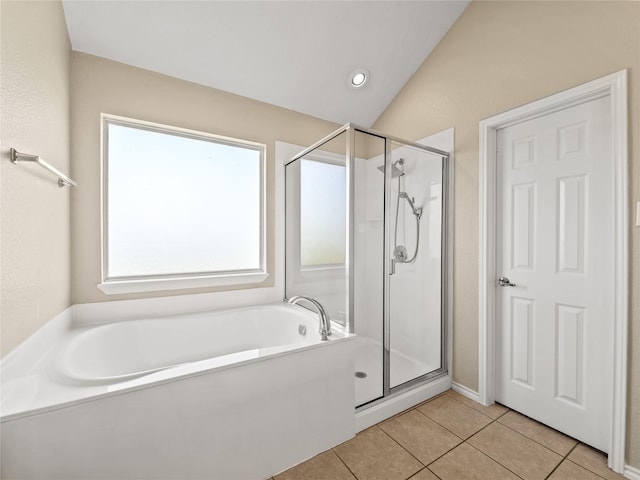 bathroom with a garden tub, tile patterned flooring, vaulted ceiling, and a stall shower