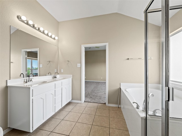 full bathroom with a bath, vaulted ceiling, a sink, and tile patterned flooring