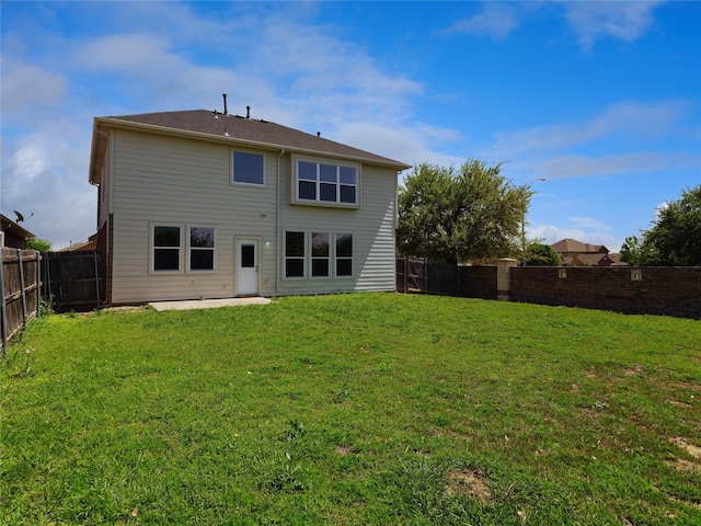 back of property with a lawn and a fenced backyard