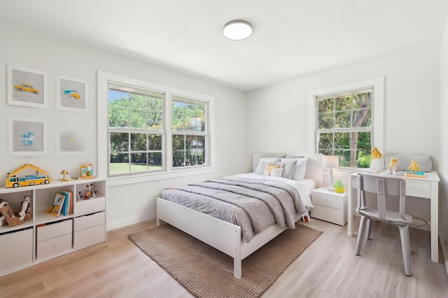 bedroom featuring light wood finished floors and multiple windows