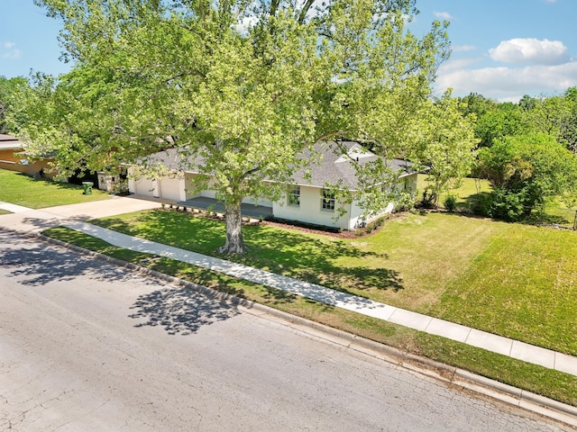 view of front of property with stucco siding, a front lawn, driveway, and a garage