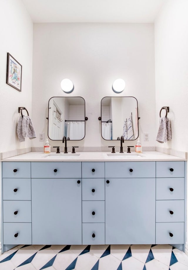 full bathroom with a sink and double vanity
